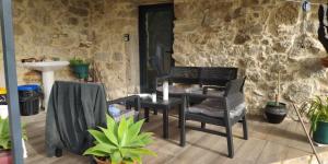 a table and chairs in front of a stone wall at Quinta da Eira in Sever do Vouga