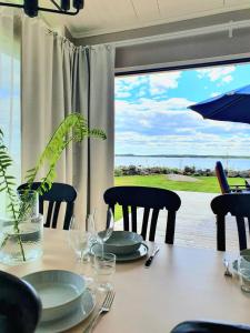 a dining room table with a view of the ocean at Stuga med havsutsikt in Robertsfors