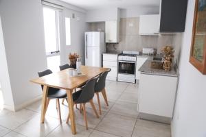 eine Küche mit Tisch und Stühlen und einem Kühlschrank in der Unterkunft Romeo Apt, p/ 4 personas, en el centro de Salta in Salta