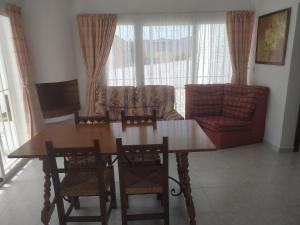 a living room with a wooden table and chairs at PARAÍSO in San Juan de los Terreros