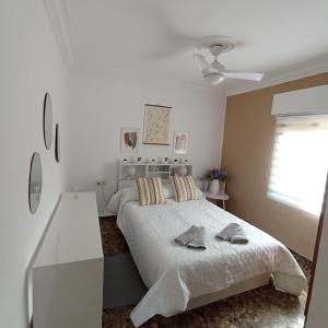 a white bedroom with a bed and a white table at Villa Manuela in Denia