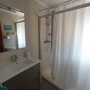 a bathroom with a shower curtain and a sink at Villa Manuela in Denia