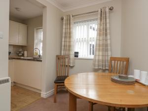 a kitchen and dining room with a wooden table and chairs at Betty's Mews in Ambleside