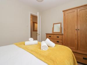sypialnia z łóżkiem z ręcznikami w obiekcie Betty's Mews w mieście Ambleside