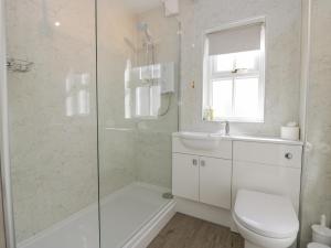 a bathroom with a shower and a toilet and a sink at Betty's Mews in Ambleside +19 photos