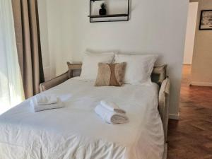a white bed with towels and pillows on it at Charme & Confort au Plessis in Le Plessis-Robinson