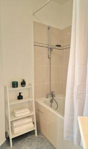 La salle de bains est pourvue d'une douche, d'une baignoire et d'un rideau de douche. dans l'établissement Charme & Confort au Plessis, au Plessis-Robinson