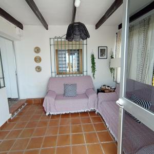 sala de estar con sofá púrpura y ventana en Villa Manuela, en Denia