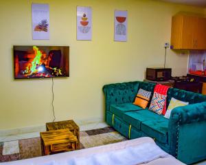 een woonkamer met een groene bank en een open haard bij The Sunset Home's in Mombasa