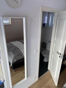 Dormitorio pequeño con cama y espejo en Ugla Gistihús (Ugla Guesthouse), en Hella