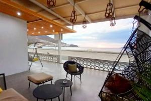 eine Veranda mit Schaukeln und Stühlen und Blick auf den Strand in der Unterkunft Casa en Playa Tortugas, Casma in Tortuga