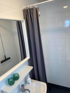 uma casa de banho com um lavatório e um espelho em Ugla Gistihús (Ugla Guesthouse) em Hella