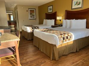 um quarto de hotel com duas camas e uma mesa em Atkinson Inn & Suites em Lumberton