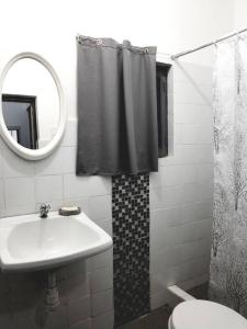 a white bathroom with a sink and a mirror at Casa en Playa Tortugas, Casma in Tortuga