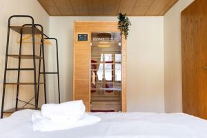 Schlafzimmer mit einem Bett mit weißer Bettwäsche und einer Leiter in der Unterkunft Ferienwohnung Schloss Kuckuckstein mit Infrarotsauna,WLAN, Hunde nach Absprache in Liebstadt