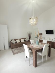 - un salon avec une table en bois et des chaises blanches dans l'établissement JEY STUDIO_INDEPENDENT SEAFRONT APARTMENT, à Terrasini