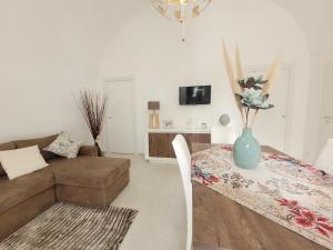- un salon avec un canapé et une table avec un vase dans l'établissement JEY STUDIO_INDEPENDENT SEAFRONT APARTMENT, à Terrasini