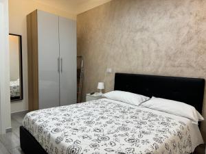a bedroom with a bed with a black and white bedspread at Meghan Home in Catania