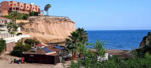 a building on a beach next to the ocean at PARAÍSO in San Juan de los Terreros