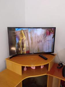 大普拉亚Kitnet Temporada Praia Grande SP - Completa com Wi-fi, garagem rotativa, 1 quadra da praia - no centro comercial Boqueirão的木架上的平面电视,配有遥控器 更多28张照片