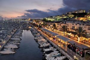a group of boats parked in a marina at night at Apartment Port D'aiguadolç Sitges in Sitges