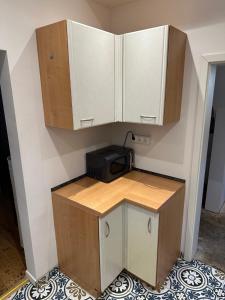 una cucina con armadietti bianchi e una stampante nera appesa a un muro di 70qm Wohnung für 4 Personen a Selzen