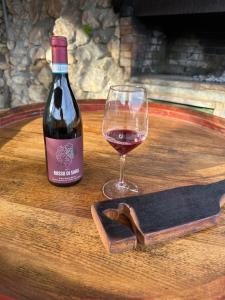 a bottle of wine and a glass on a barrel at Val di Venere Glamp House in Santa Maria in Stelle