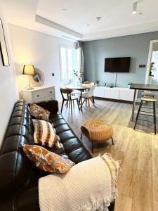 un salon avec un canapé en cuir et une table dans l'établissement Grand Central House - Central Penthouse Two Bedroom - GibraltarStay Apartments, à Gibraltar