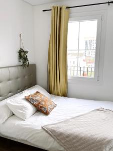 - un lit avec un oreiller et une fenêtre dans l'établissement Stunning City Centre Penthouse with Private Balcony - Grand Central House, à Gibraltar