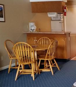 a kitchen with three chairs and a table and a counter at Windrifter Resort in Wolfeboro