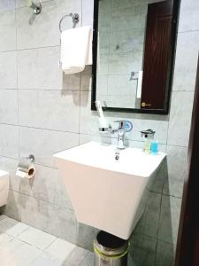 y baño con lavabo blanco y espejo. en فندق دره الراشد للشقق المخدومه en Riad