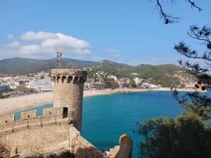 a view of a beach with a tower and a beach at Apartamento Coral in Tossa de Mar