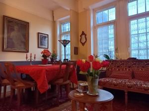 a living room with a table with flowers and a couch at Villa des Chats in Calais