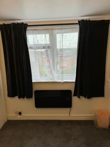 a window with black curtains and a speaker in a room at Oleon Rooms - Central Reading in Reading