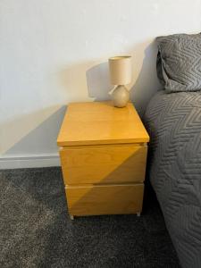 a nightstand with a lamp on it next to a bed at Oleon Rooms - Central Reading in Reading