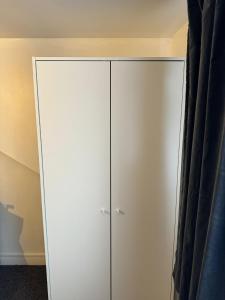 a white cabinet in a room with a curtain at Oleon Rooms - Central Reading in Reading