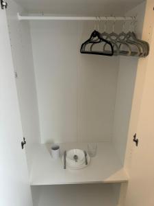 a white cupboard with a shelf with cups and aucer at Oleon Rooms - Central Reading in Reading