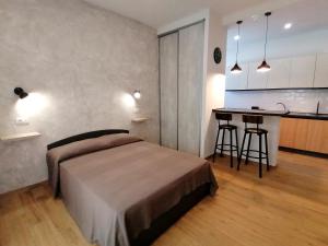 a bedroom with a bed and a kitchen with a counter at Urban Loft in Lido di Ostia