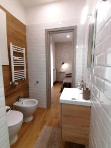 a white bathroom with two sinks and a toilet at Urban Loft in Lido di Ostia