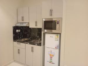 La cuisine est équipée d'un réfrigérateur et d'un four micro-ondes. dans l'établissement فندق دره الراشد للشقق المخدومه, à Riyad