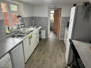 a kitchen with a sink and a refrigerator at Oleon Rooms - Central Reading in Reading