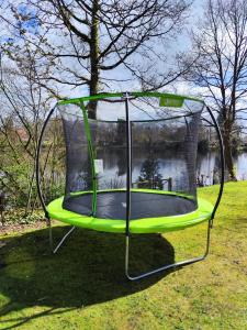 a trampoline in the grass in a yard at Ferienhaus blauer See mit optionalem Hot-Tub in Bockhorn +41 photos