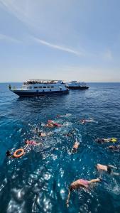 a group of people in the water with a boat at Hurghada Tours in Hurghada