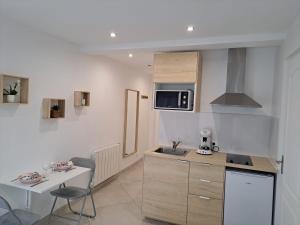 a small kitchen with a sink and a microwave at Studio Beauvais avec terrasse privative calme & tout confort in Beauvais