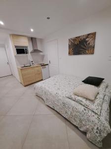 ein weißes Schlafzimmer mit einem Bett und einer Küche in der Unterkunft Studio Beauvais in Beauvais