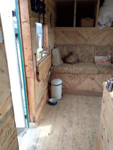a small room with a couch in a wooden trailer at Charming 1-Bed Cabin in oving in Chichester