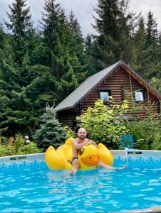 un hombre montado en una balsa amarilla en una piscina en Cottage Kalinka en Bukovel