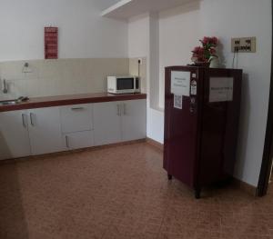 a kitchen with a refrigerator and a microwave at 7TH HEAVEN Kannur in Chakkarakkal