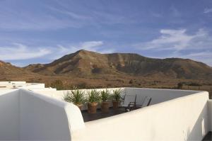 einen Balkon mit Pflanzen und einem Berg im Hintergrund in der Unterkunft Hotel Los Patios - Parque Natural in Rodalquilar