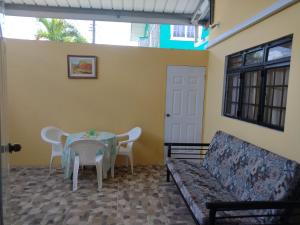 a living room with a couch and a table and chairs at Tessa's Inn in Arima